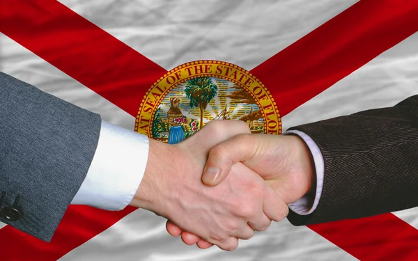 Frente a la bandera del estado americano de Florida dos hombres de negocios manos — Foto de Stock