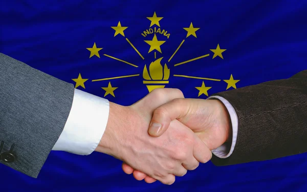 Stock image In front of american state flag of indiana two businessmen hands