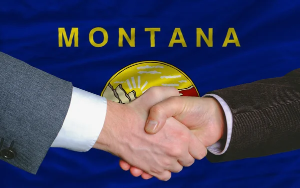 In front of american state flag of montana two businessmen hands — Stock Photo, Image