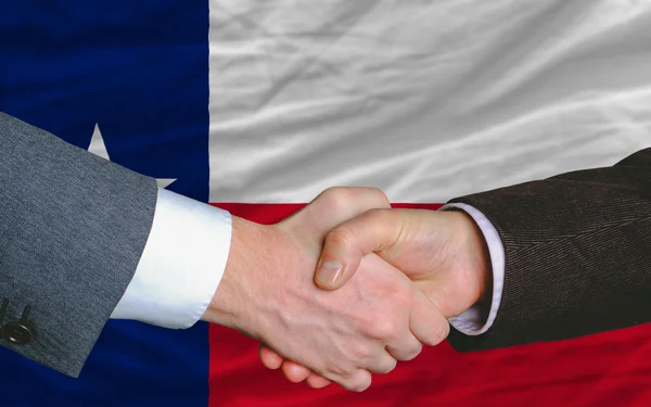 Vor der amerikanischen Staatsflagge von Texas zwei Geschäftsleute handsha — Stockfoto