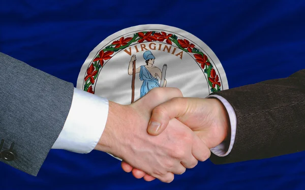 Virginia amerikai állam zászlaja előtt két üzletemberek kéz — Stock Fotó