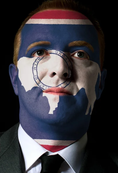 Us state of wyoming flag painted face of businessman or politici — Stock Photo, Image