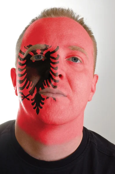 Face of serious patriot man painted in colors of albania flag — Stock Photo, Image