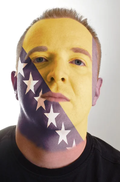 Gesicht eines ernsthaften Patrioten gemalt in den Farben Bosnien-Herzegowinas — Stockfoto