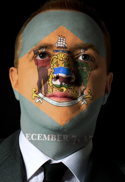 Us state of delaware flag painted face of businessman or politic — Stock Photo, Image