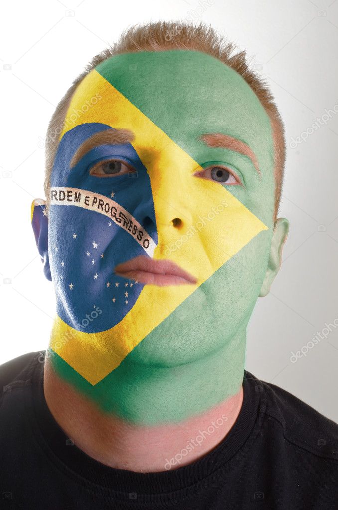 Face of serious patriot man painted in colors of brazil flag