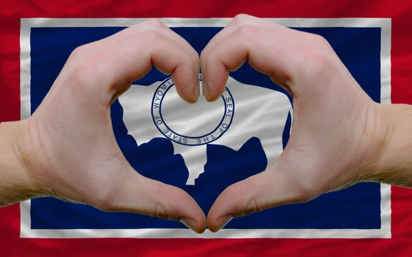 Over american state flag of wyoming showed heart and love gestur — Stock Photo, Image