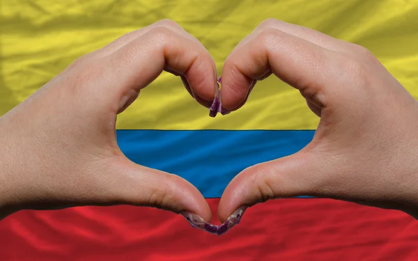 Over national flag of colombia showed heart and love gesture mad — Stock Photo, Image