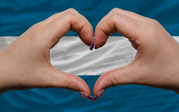 Over national flag of el salvador showed heart and love gesture — Stock Photo, Image