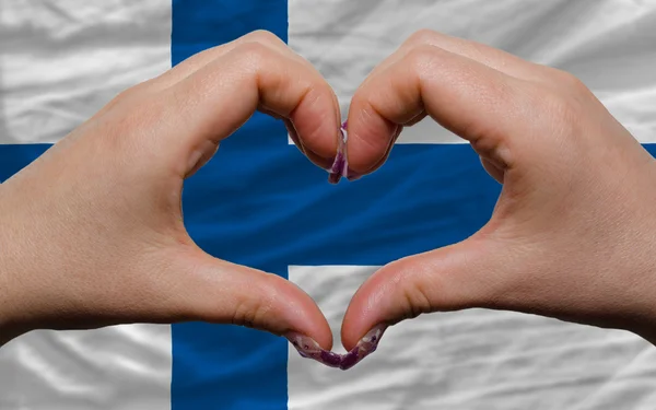 Over national flag of finland showed heart and love gesture made — Stock Photo, Image
