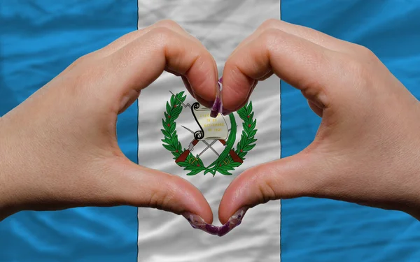 Over national flag of guatemala showed heart and love gesture ma — Stock Photo, Image