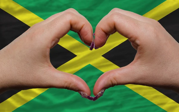 Over national flag of jamaica showed heart and love gesture made — Stock Photo, Image
