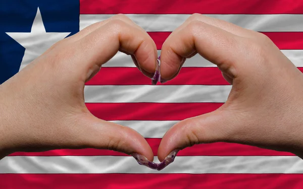 Over national flag of liberia showed heart and love gesture made — Stock Photo, Image