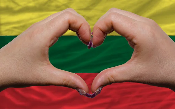 Over national flag of lithuania showed heart and love gesture ma — Stock Photo, Image
