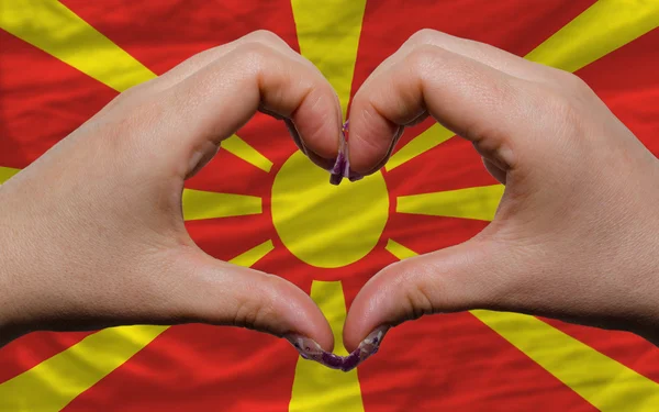 Над национальным флагом Мачедонии проявили сердце и любовь жест ма — стоковое фото