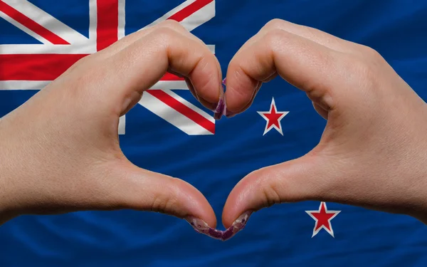 Over national flag of new zealand showed heart and love gesture — Stock Photo, Image