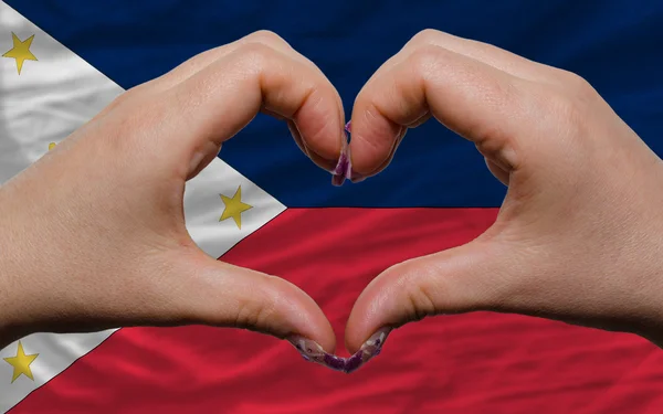 Over national flag of philippines showed heart and love gesture — Stock Photo, Image