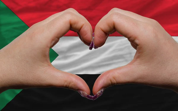 Sobre a bandeira nacional de sudan mostrou coração e amor gesto feito b — Fotografia de Stock
