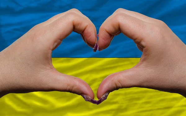 Over national flag of ukraine showed heart and love gesture made — Stock Photo, Image