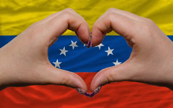 Over national flag of venezuela showed heart and love gesture ma — Stock Photo, Image