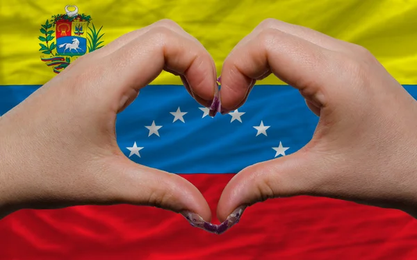 Over nationale vlag van venezuela toonde hart en liefde gebaar ma — Stockfoto