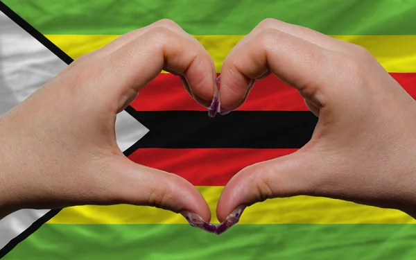 Over national flag of zimbabwe showed heart and love gesture mad — Stock Photo, Image