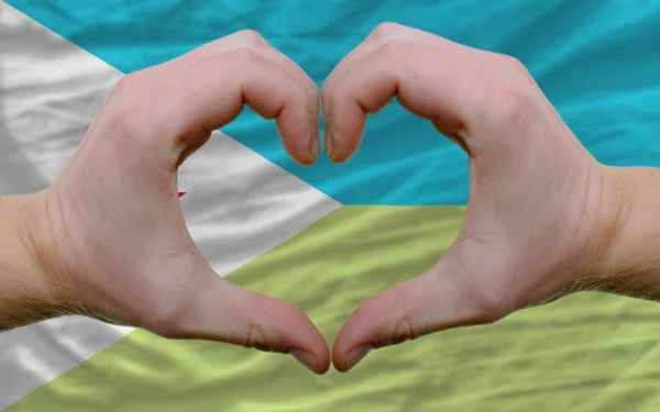 Over flag of djibuti showed heart and love gesture made by hands — Stock Photo, Image