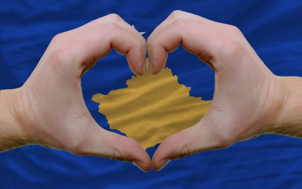 Over vlag van kosovo toonde hart en liefde gebaar gemaakt door handen — Stockfoto