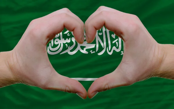 サウジアラビアの旗の上で作られた心と愛のジェスチャーを示した — ストック写真