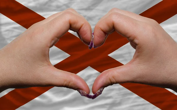Přes americké státní vlajka alabama ukázala srdce a láska gestur — Stock fotografie