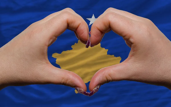 Über der Flagge Kosovos zeigte Herz und Geste der Liebe, die von Händen gemacht wurde — Stockfoto