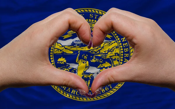 Über der amerikanischen Staatsflagge von Nebraska zeigte Herz und Liebe gestu — Stockfoto