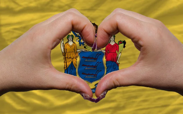 Over american state flag of new jersey showed heart and love ges — Stock Photo, Image