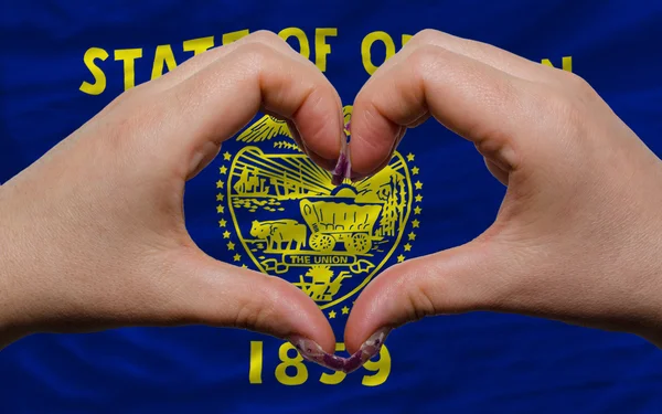 Over american state flag of oregon showed heart and love gesture — Stock Photo, Image