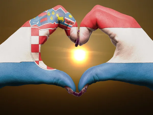 Жест любви и сердца руками, раскрашенными в хорватский флаг во время b — стоковое фото