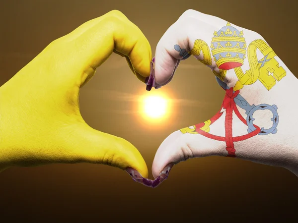 Жест любви и сердца руками, раскрашенными в ватиканский флаг в течение b — стоковое фото