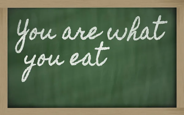Wyrażenie - jesteś co jesz - napisane na blackbo szkoły — Zdjęcie stockowe