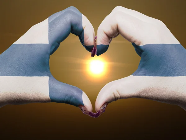 Szív és a szeretet gesztusa, kezében színes finn lobogó alatt b — Stock Fotó