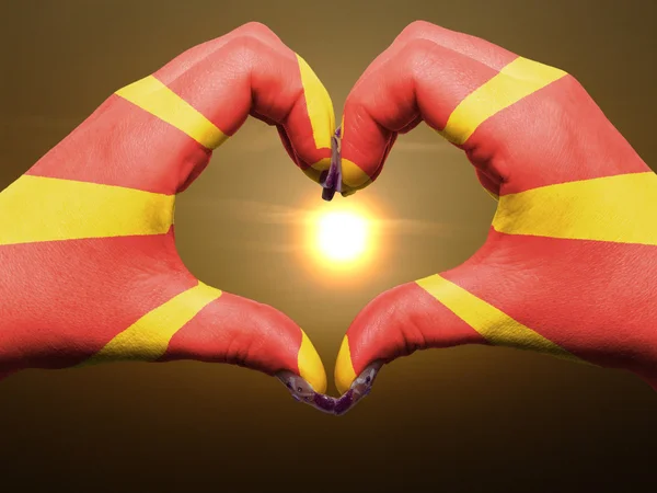 Жест любви и сердца руками, раскрашенными в македонский флаг во время — стоковое фото