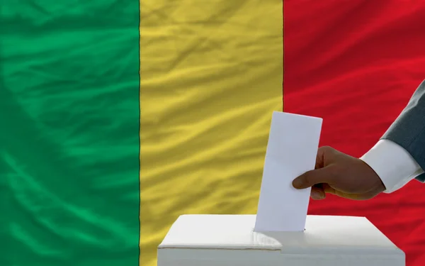 Człowiek głosowania w wyborach przed flagi narodowej z mali — Zdjęcie stockowe