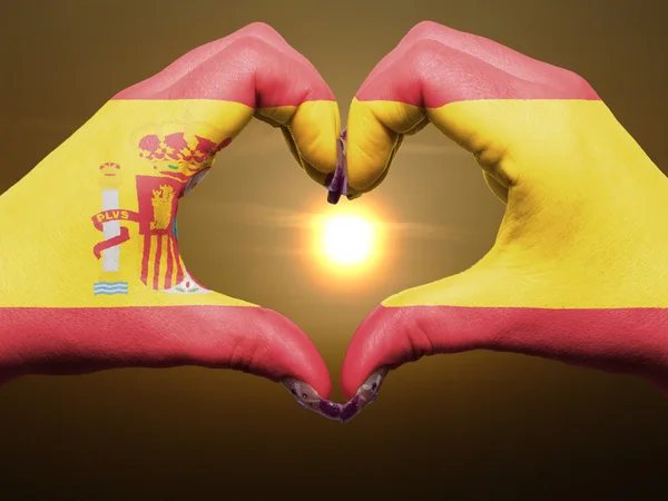 Жест любви и сердца руками, раскрашенными в испанский флаг во время бобы — стоковое фото
