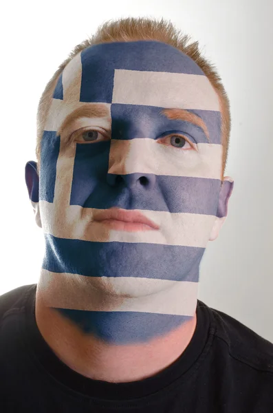 Gezicht van ernstige patriot man geschilderd in kleuren van Griekenland vlag — Stockfoto