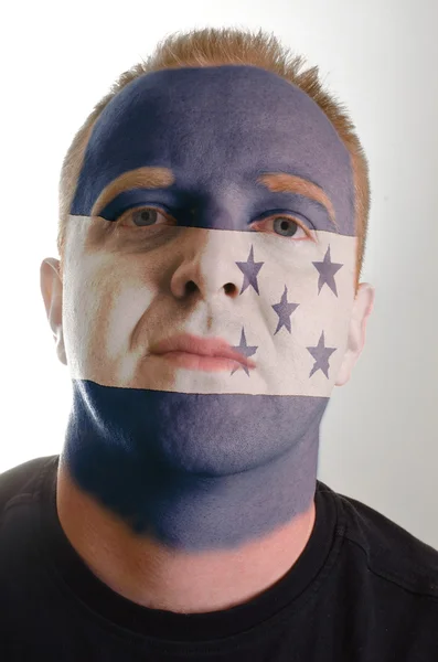 Face of serious patriot man painted in colors of honduras flag — Stock Photo, Image