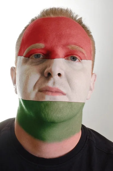 Лицо серьезного патриота, раскрашенного в цвета венгерского флага — стоковое фото