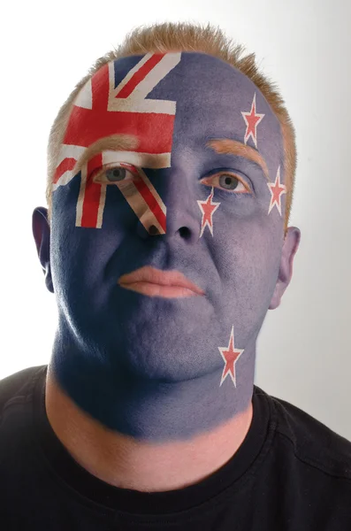 Face of serious patriot man painted in colors of new zealand fla — Stock Photo, Image