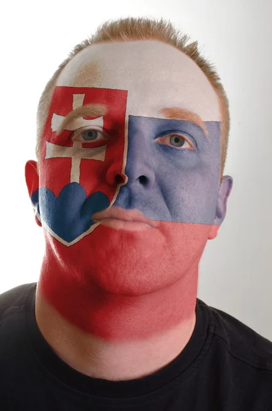 Cara de homem patriota sério pintado em cores de bandeira da Eslováquia — Fotografia de Stock