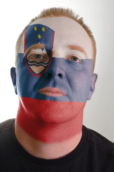 Face of serious patriot man painted in colors of slovenia flag — Stock Photo, Image