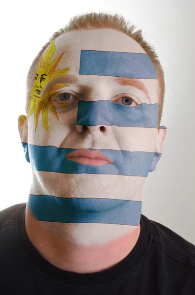 Face of serious patriot man painted in colors of uruguay flag — Stock Photo, Image