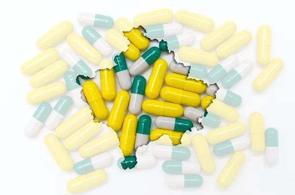 Outline map of kosovo with pills in the background for health an — Stock Photo, Image