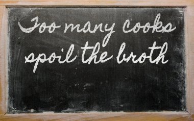 Expression - too many cooks spoil the broth - written on a scho clipart